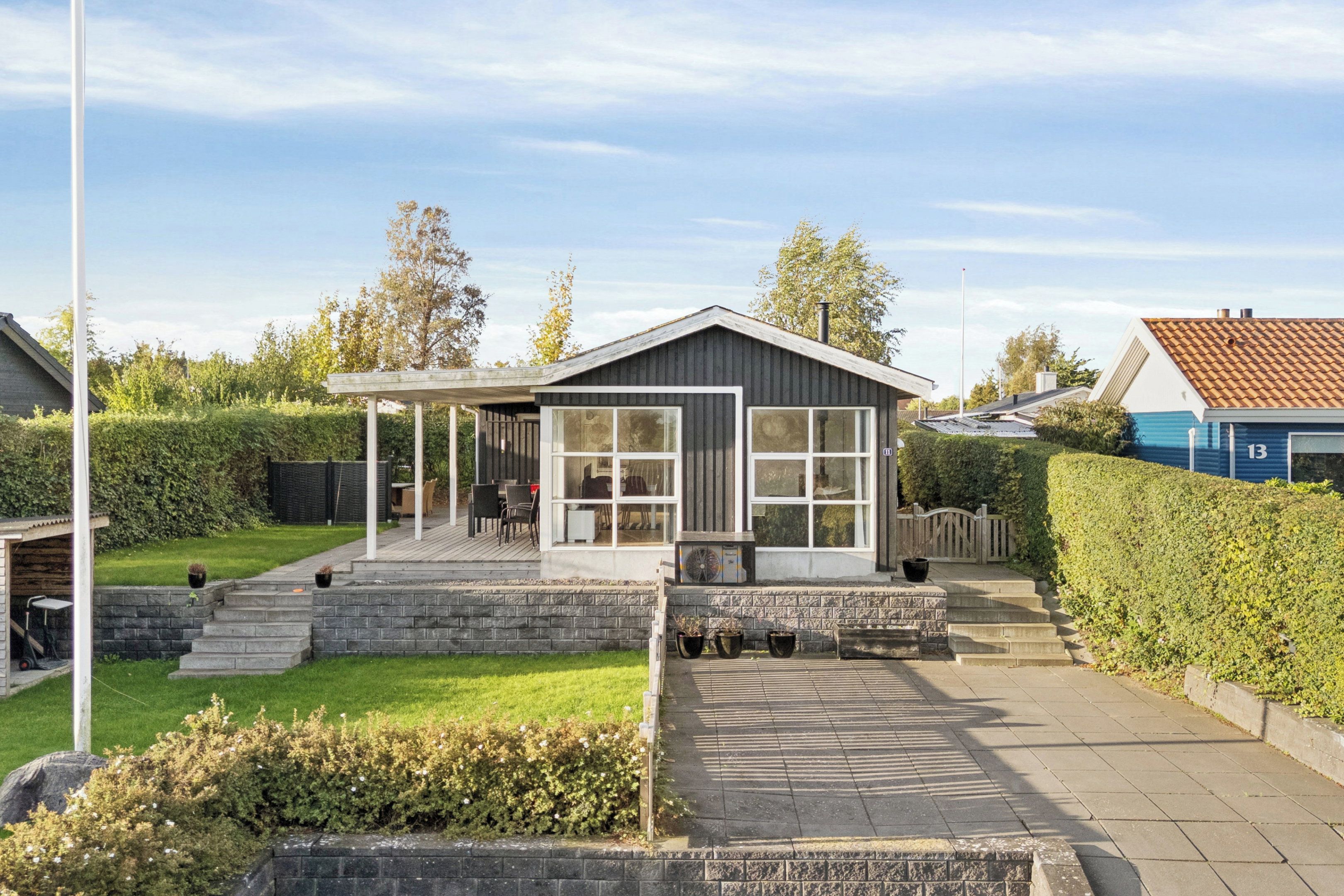 A modern house with a covered porch, a stone staircase, and a well-maintained garden.