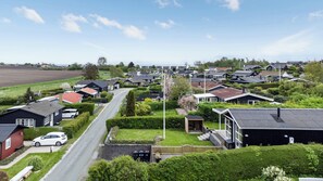 A residential area with houses, a road, and a flagpole. - Cosy holiday home near Kerteminde (Kerteminde)