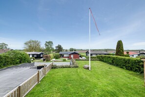A residential area with houses, a flagpole, and a well-maintained lawn. - Cosy holiday home near Kerteminde (Kerteminde)