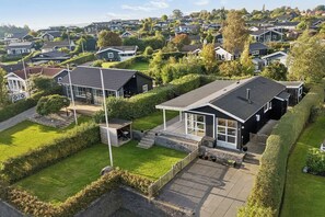 A residential area with houses, a well-maintained lawn, and a clear sky.