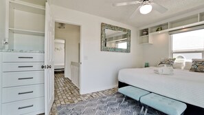 Un dormitorio con cama, cómoda, espejo y ventana.