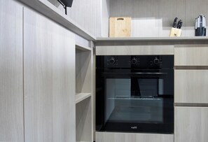 Eine moderne Küche mit Einbauofen und einer Holzt Schneidebrett auf der Arbeitsplatte.