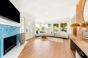 A spacious living room with a fireplace, a sofa set, and a coffee table. - The Tourmaline Beach House - Walk to Surf & Sand (San Diego)