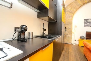 A modern kitchen with a black countertop, a coffee machine, and a sink. - Loft con Archi Romani | Cuore di Trastevere (Rome)