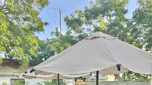 Een houten terras met banken en een parasol.
