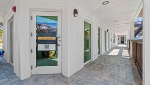 Un pasillo con puertas, un código QR y un número de contacto para OCTA COLLECTION.