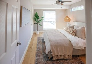 A bedroom with a bed, a ceiling fan, a potted plant, and a window. - South Congress Oasis | Pool, Hot Tub & Sunroom (Austin)