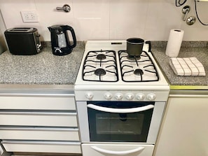 Eine Küche mit einem weißen Herd, einem schwarzen Toaster und einer Kaffeemaschine.