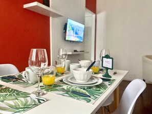 A breakfast table set with glasses, cups, and a sign, in a room with a TV in the background. - 157- Apt. with Great Location for 3 p. in Recoleta (Buenos Aires)