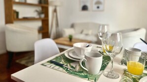 A dining table set with white cups, a glass of orange juice, and a knife on a leaf-patterned placemat. - 157- Apt. with Great Location for 3 p. in Recoleta (Buenos Aires)