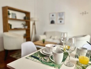 A dining table set with white cups, a glass of orange juice, and a knife on a leaf-patterned placemat. - 157- Apt. with Great Location for 3 p. in Recoleta (Buenos Aires)