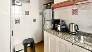 A compact kitchen with white cabinets, a granite countertop, a microwave, a coffee maker, and a kettle. - 157- Apt. with Great Location for 3 p. in Recoleta (Buenos Aires)