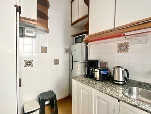 A compact kitchen with white cabinets, a granite countertop, a microwave, a coffee maker, and a kettle. - 157- Apt. with Great Location for 3 p. in Recoleta (Buenos Aires)