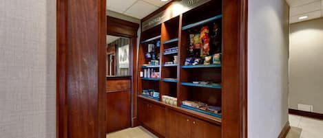 A hallway with a snack bar featuring shelves stocked with various food items.