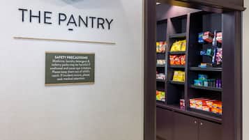 A section labeled 'THE PANTRY' with safety precautions and a variety of snacks and household items on shelves.