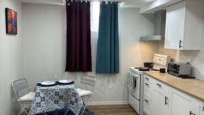 A compact kitchen with white cabinets, a microwave, and a stove.