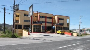 Un edificio de varios pisos con un restaurante y una plaza de hotel en la planta baja.