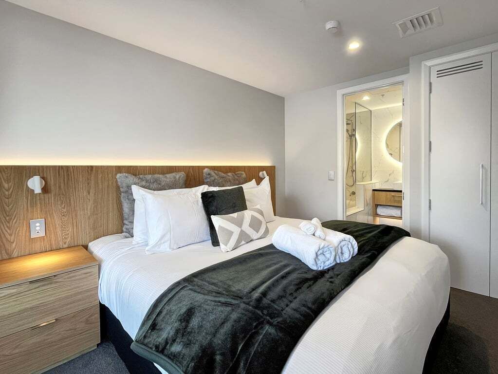 Ein Hotelzimmer mit Bett, Nachttisch und begehbarem Kleiderschrank.