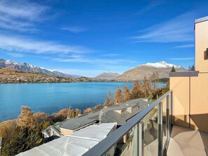 A modern building with a balcony overlooking a lake and mountains. - Above the Lake | Lakeview Getaway (Queenstown)