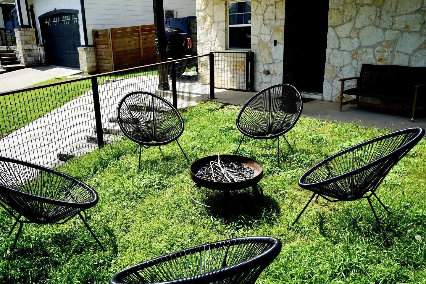 Un área de estar al aire libre con cuatro sillas y un brasero.