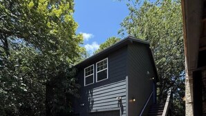 A two-story building with a garage, a driveway, and a staircase leading to the upper level. - Chef's Kitchen · Game Room+Casita · Group Ready! (Austin)