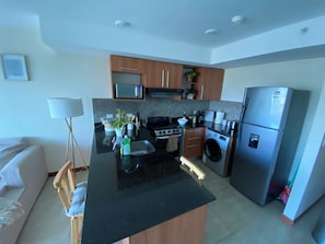 A modern kitchen with a central island, built-in appliances, and a microwave above the countertop. - Relaxing, Cozy Apartment on the 20th Floor! AC Wi-Fi Pool (San Jose)