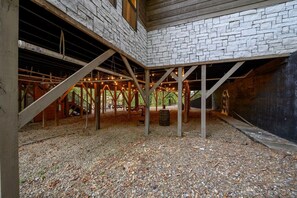 A building with a stone facade, wooden beams, and a gravel floor. - Peaceful Easy Feeling · Woodland Retreat: Hot Tub, Swing Chairs, Fire Pit (Broken Bow)