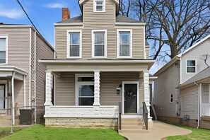 A two-story residential house with a front porch, a chimney, and a satellite dish. - Louisville Charm 5BR Retreat | Expo | Dwntwn (Louisville)