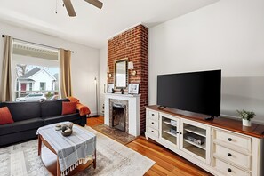 Uma sala de estar moderna com lareira, televisão e sofá.