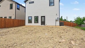 A two-story residential building with a sloped roof, a front door, and a small porch area. - New Furnished 3BR 31+ Day Stay Corporate and Family Friendly Garage + Wi-Fi (Fort Worth)