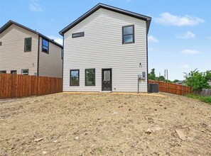 A two-story residential building with a sloped roof, a front door, and a small porch area. - New Furnished 3BR 31+ Day Stay Corporate and Family Friendly Garage + Wi-Fi (Fort Worth)
