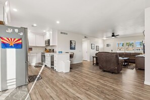 A modern kitchen with white cabinets, a refrigerator, and a microwave. - Rolling Hills Haven | 3BR | Large Screened Patio | Fenced Yard | Sun City | Sleeps 6 (Sun City)