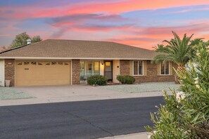 A single-story house with a garage, a front porch, and a driveway. - Rolling Hills Haven | 3BR | Large Screened Patio | Fenced Yard | Sun City | Sleeps 6 (Sun City)