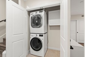 Una sala de lavandería con lavadoras y secadoras apiladas.