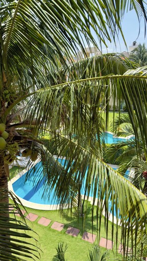 A pool surrounded by palm trees and a well-maintained lawn. - Spacious 3-bedroom apartment with a pool in Boca del Río (boca del rio)