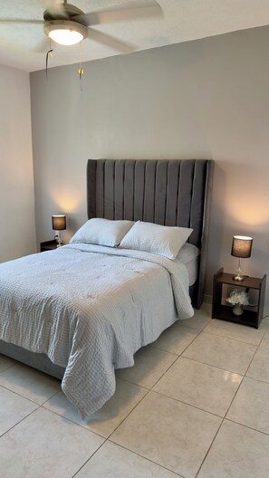 A bedroom with a bed, two bedside lamps, a ceiling fan, and a nightstand with a vase. - Spacious 3-bedroom apartment with a pool in Boca del Río (boca del rio)