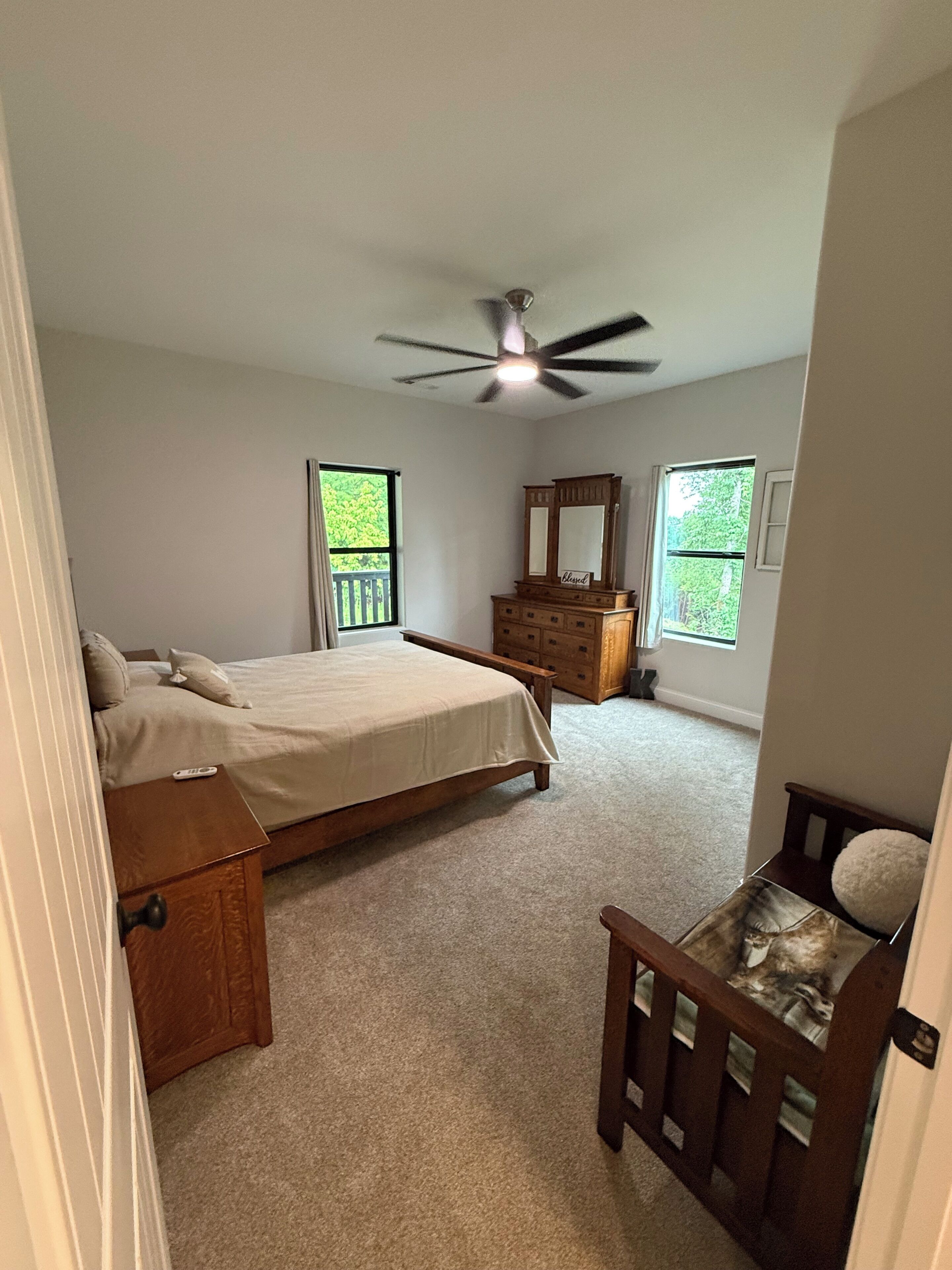 Une chambre à coucher avec un lit, une commode et un ventilateur de plafond.
