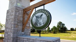 A circular sign with a cat illustration and the text 'HEAD FARM' against a clear sky. - Owl's Head Haven 235-4 Bed House-Unfurnished (Freeport)