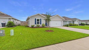 A residential area with houses featuring front yards, a small tree, and a clear sky. - Owl's Head Haven 235-4 Bed House-Unfurnished (Freeport)