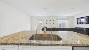 A kitchen with a granite countertop, stainless steel sink, and a built-in oven. - Owl's Head Haven 235-4 Bed House-Unfurnished (Freeport)