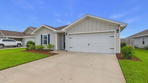A residential house with a garage, a driveway, and a lawn. - Owl's Head Haven 235-4 Bed House-Unfurnished (Freeport)