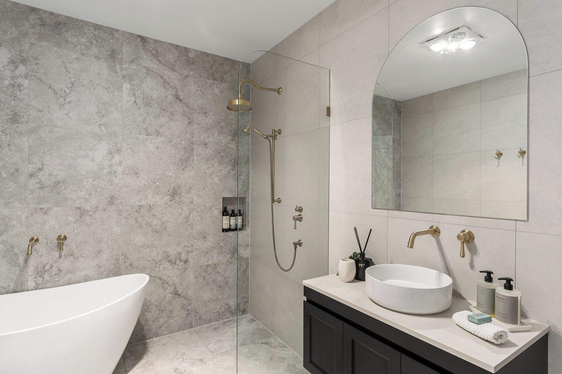 A modern bathroom with a freestanding bathtub, a glass-enclosed shower, and a vanity with a large mirror.