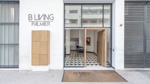 A building entrance with a sign reading 'B L I V I N G PALMIER'. - Palmier • 1BR avec balcon & parking (Casablanca)