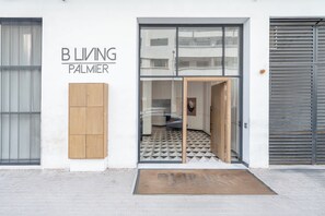 A building entrance with a sign reading 'B L I V I N G PALMIER'. - Palmier • 1BR avec balcon & parking (Casablanca)