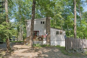 A cabin with a porch, surrounded by trees.
