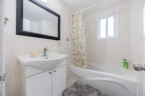 Ein Badezimmer mit Waschbecken, Spiegel und Badewanne.
