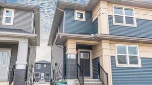 A residential building with a front door, a visible number '32', and a staircase leading to the entrance. - Luxurious  4-bedroom house w/ Free Banff Pass (Northeast)