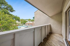 Ein Balkon mit Blick auf einen Swimmingpool und die umliegenden Gebäude.