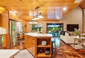 A modern kitchen with wooden cabinets, stainless steel appliances, and a central island. - Heated Pool | Boat Parking | Outdoor Kitchen (Broken Bow)