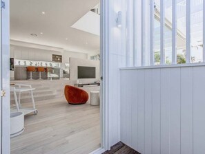 A modern interior with a kitchen, dining area, and a large window. - 23 Lancelin Drive Mermaid Waters (Gold Coast)